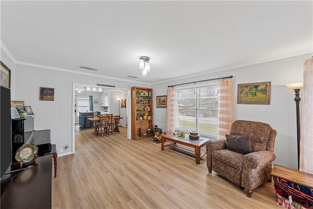 living area featuring ornamental molding and light wood-type flooring