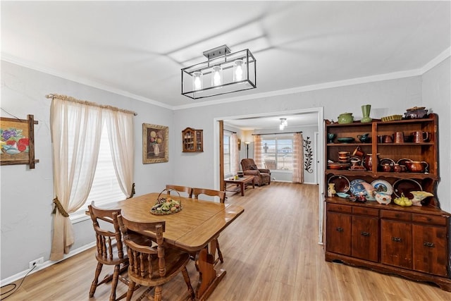 dining area featuring ornamental molding and light hardwood / wood-style floors