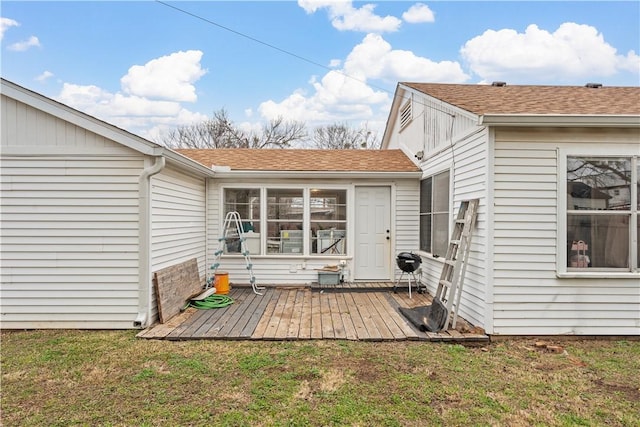 exterior space featuring a wooden deck and a lawn