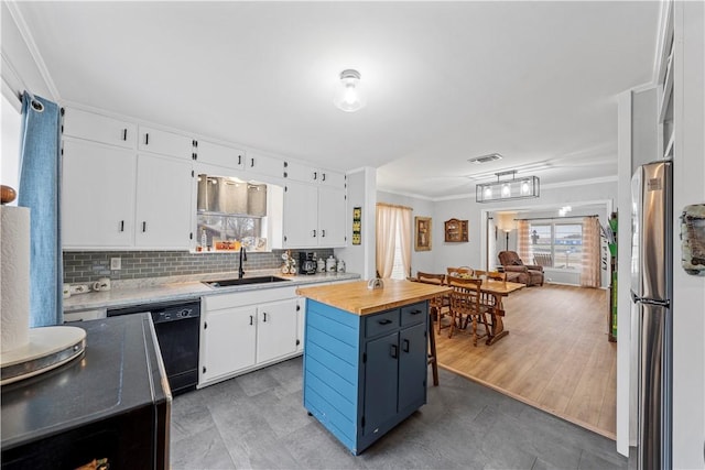 kitchen with sink, stainless steel fridge, dishwasher, white cabinetry, and a kitchen island