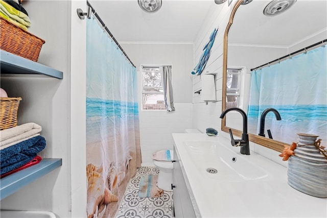 bathroom with crown molding, toilet, tile patterned flooring, and tile walls