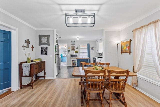 dining space featuring light hardwood / wood-style flooring and ornamental molding