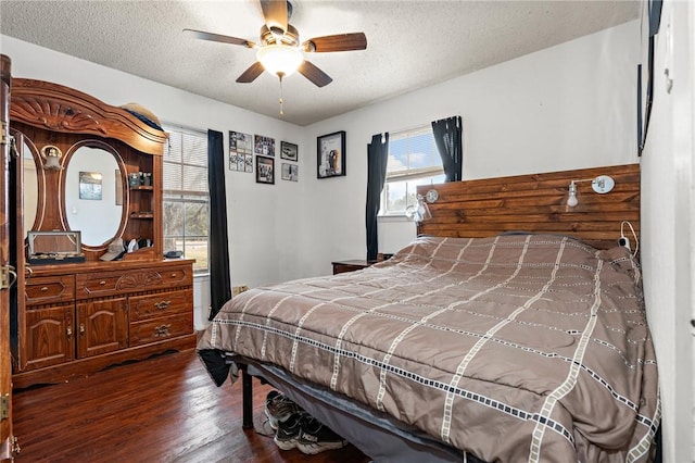 bedroom featuring ceiling fan, a textured ceiling, and dark hardwood / wood-style floors