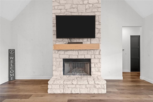 interior details featuring wood-type flooring and a stone fireplace