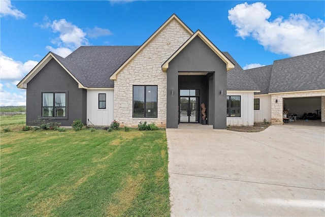 view of front of property featuring a front yard, french doors, and a garage