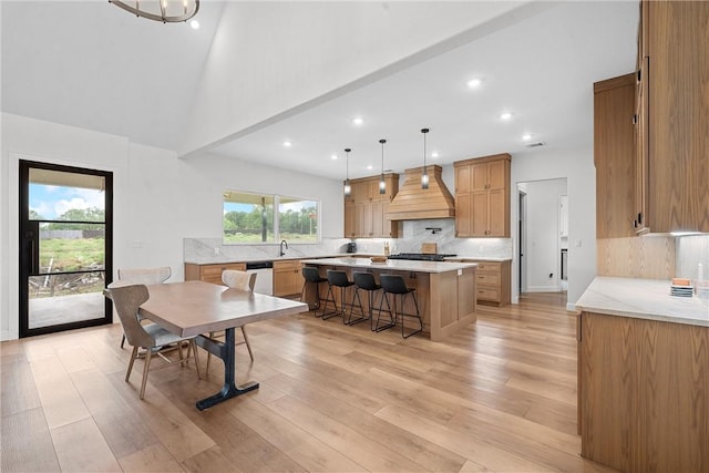 dining room with sink, light hardwood / wood-style floors, and vaulted ceiling