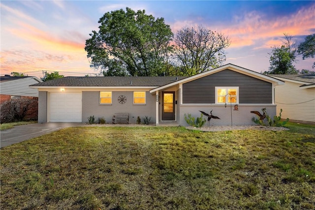 ranch-style home with a yard and a garage