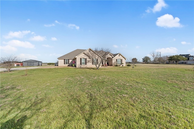 single story home featuring an outbuilding and a front lawn