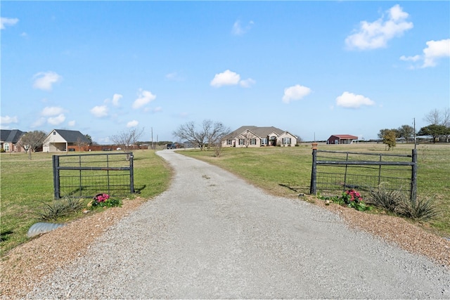 view of road with a rural view, driveway, a gated entry, and a gate