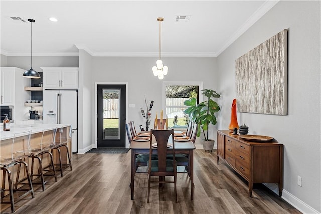 dining space with an inviting chandelier, dark hardwood / wood-style floors, and ornamental molding