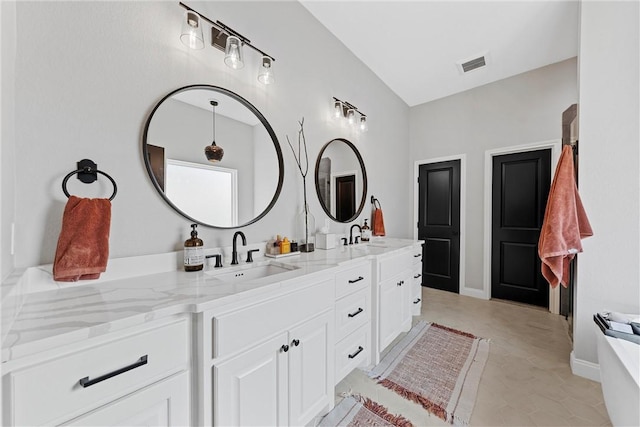 bathroom featuring tile patterned flooring, vanity, and vaulted ceiling