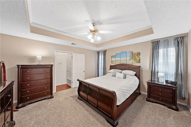 bedroom featuring a textured ceiling, carpet floors, a raised ceiling, and ceiling fan