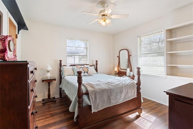 bedroom with dark wood finished floors, a ceiling fan, and baseboards