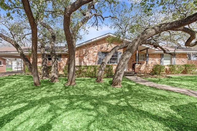 ranch-style home with brick siding and a front lawn