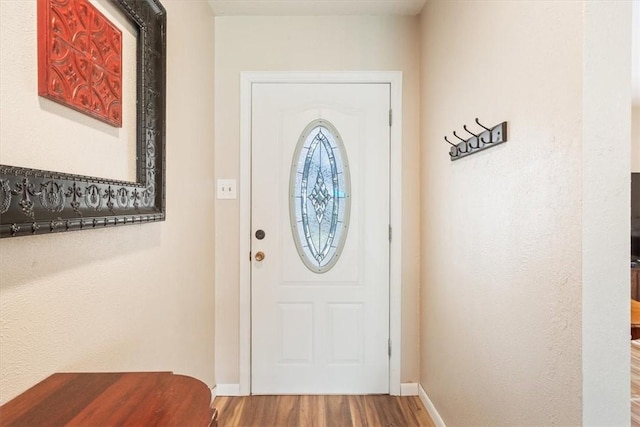 foyer featuring wood finished floors and baseboards