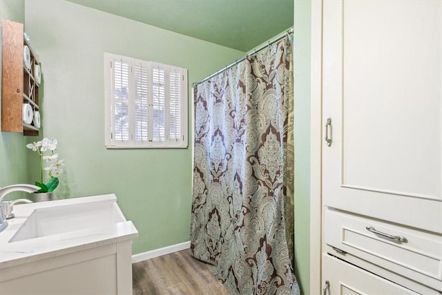 full bathroom with a shower with curtain, wood finished floors, vanity, and baseboards