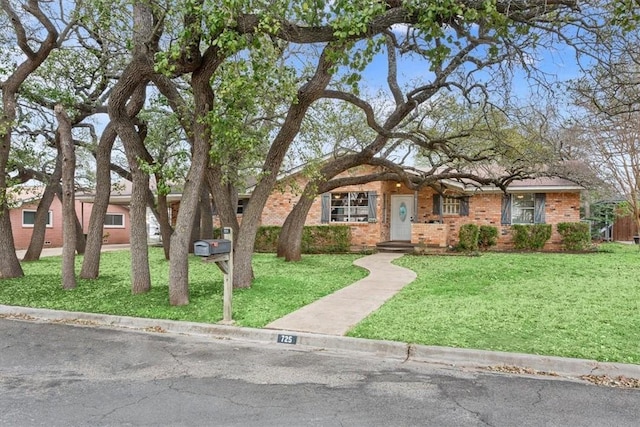 ranch-style home with brick siding and a front yard