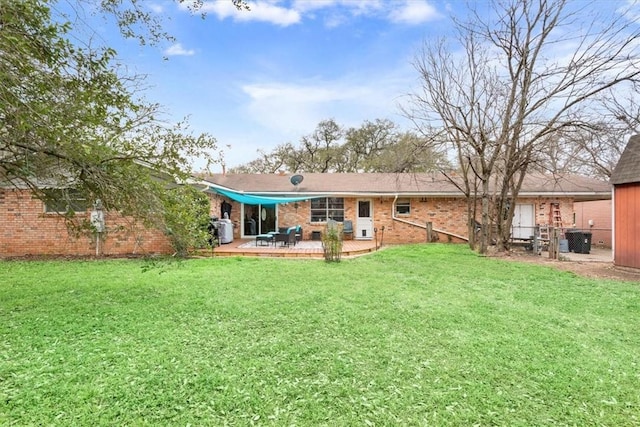 rear view of property featuring brick siding and a yard