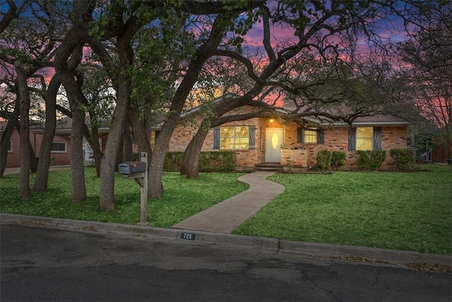 ranch-style home with a front lawn and brick siding