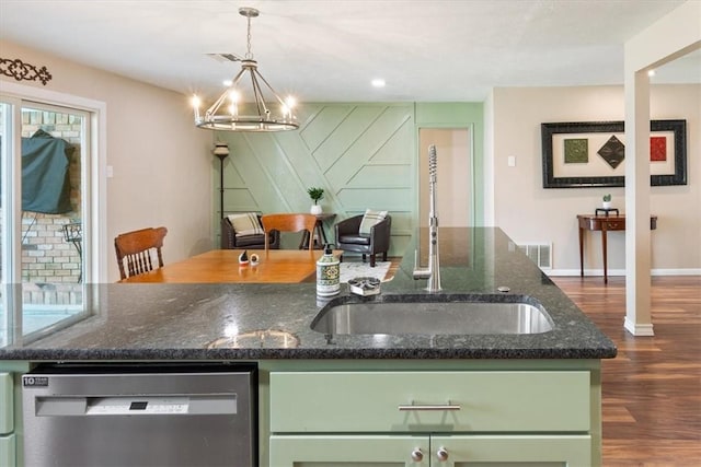 kitchen with visible vents, dark wood finished floors, stainless steel dishwasher, green cabinets, and a sink