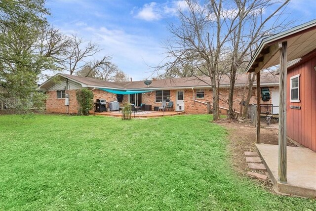 back of property featuring a patio, brick siding, and a lawn