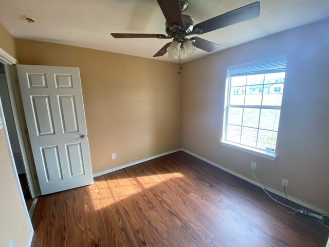 empty room with ceiling fan and hardwood / wood-style floors