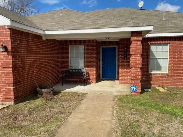 entrance to property with a lawn