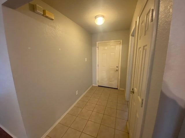 hall with light tile patterned floors