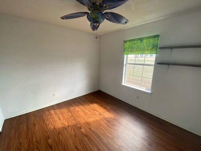 empty room with wood-type flooring and ceiling fan