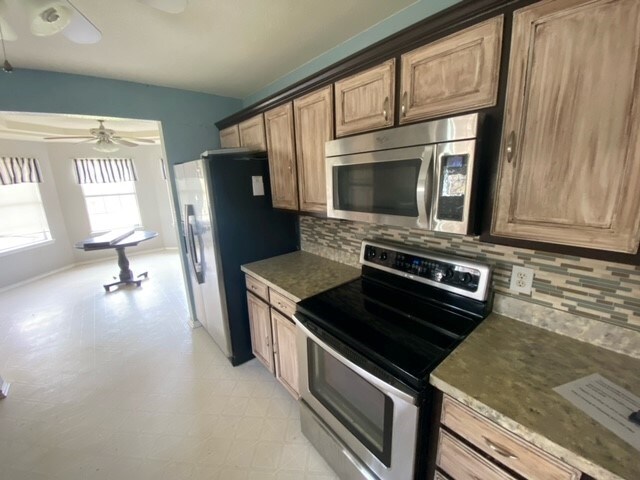 kitchen featuring tasteful backsplash, ceiling fan, and appliances with stainless steel finishes