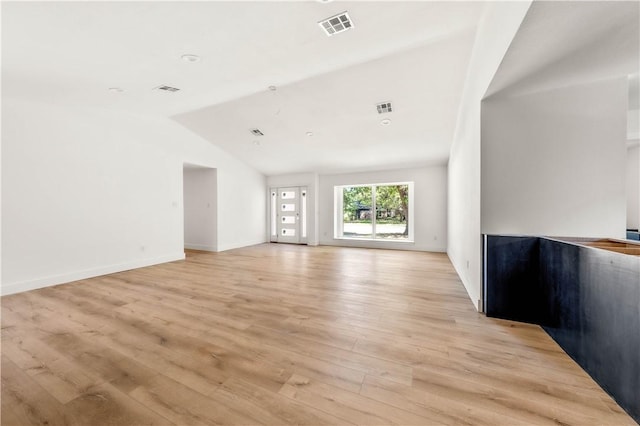 unfurnished living room with light hardwood / wood-style floors and lofted ceiling