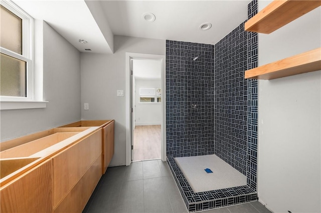 bathroom featuring tile patterned flooring and tiled shower