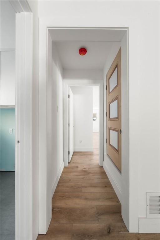 hallway with hardwood / wood-style flooring