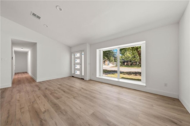 unfurnished living room featuring vaulted ceiling and light wood-type flooring