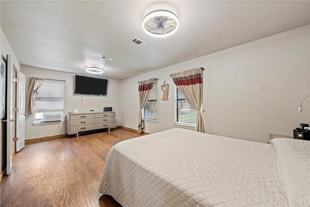 bedroom with hardwood / wood-style floors and multiple windows