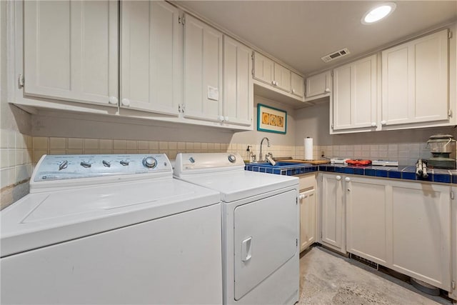 laundry area with cabinets, independent washer and dryer, and sink