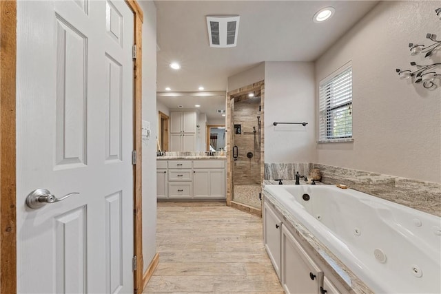 bathroom featuring independent shower and bath, vanity, and wood-type flooring