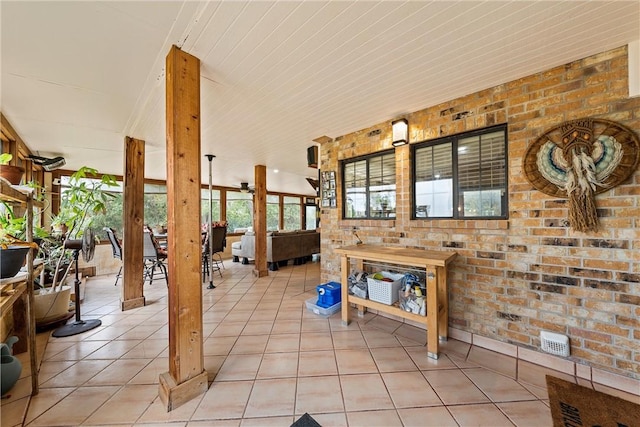 living room with light tile patterned floors and brick wall