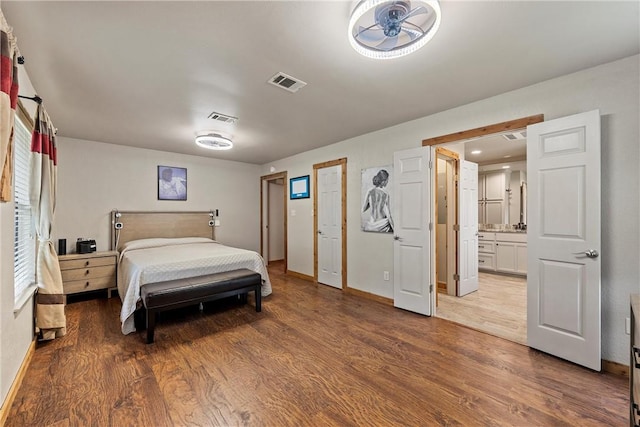 bedroom featuring connected bathroom and hardwood / wood-style flooring