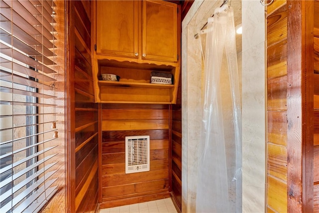 interior space with wood walls and light tile patterned flooring