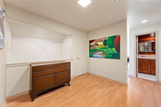 bedroom with light hardwood / wood-style floors and connected bathroom