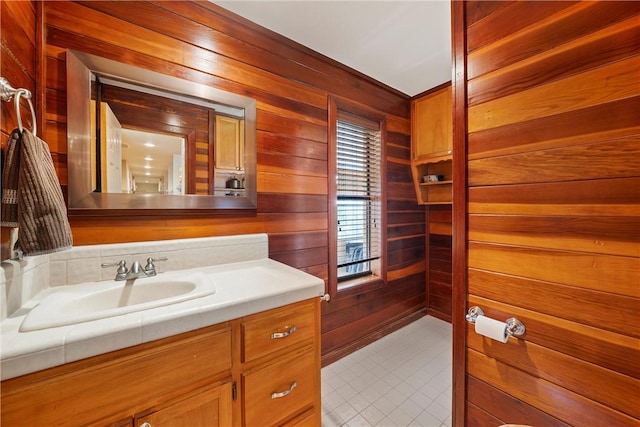 bathroom with vanity, tile patterned floors, and wood walls