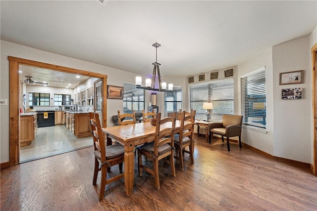 dining space with plenty of natural light, an inviting chandelier, and light hardwood / wood-style flooring