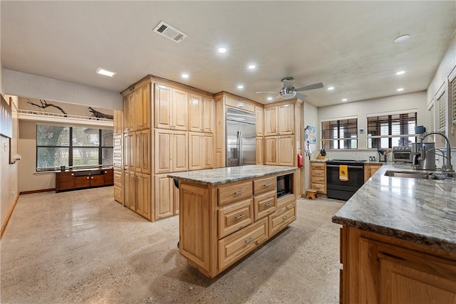 kitchen featuring black appliances, a kitchen island, a healthy amount of sunlight, and sink