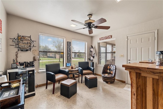 sitting room with ceiling fan and wine cooler