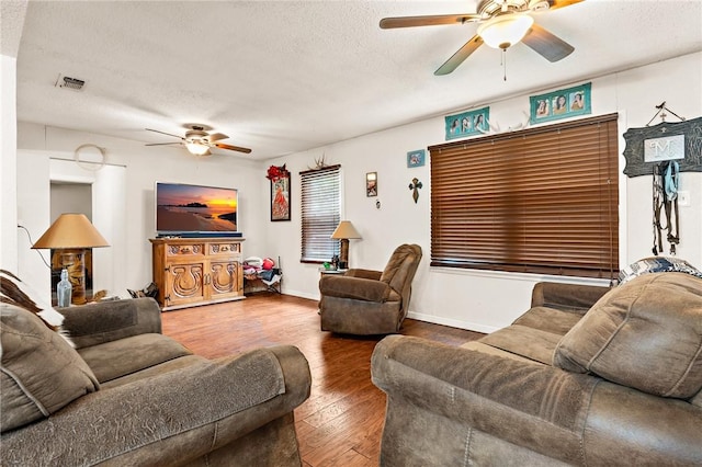 living room featuring wood-type flooring and a textured ceiling