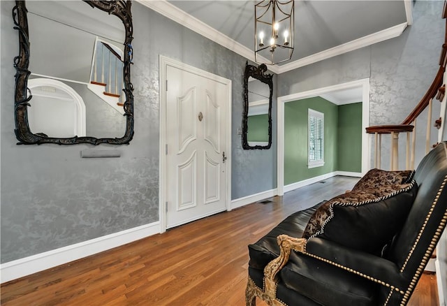 interior space with a chandelier, wood-type flooring, and ornamental molding