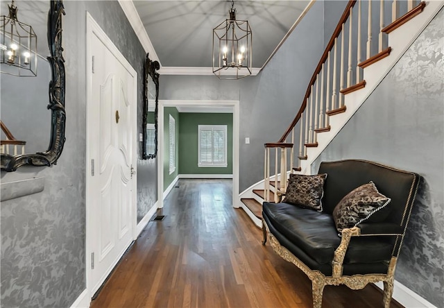 entrance foyer with a chandelier, dark hardwood / wood-style floors, and ornamental molding