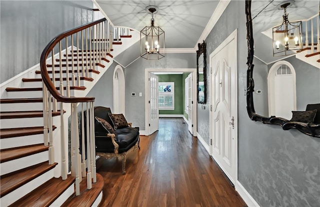 entryway featuring ornamental molding, dark hardwood / wood-style flooring, and a notable chandelier