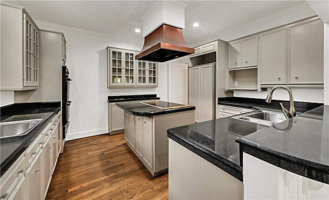 kitchen featuring a center island, sink, dark hardwood / wood-style floors, double oven, and island exhaust hood